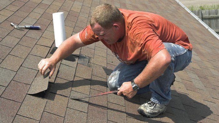 Contractor inspecting Lemont home roof before he makes a repair.